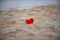 red heart in the sand on the beach