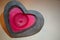 Red heart shaped candle. Heart shape red candle surrounded with black stone