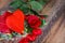 Red heart-shaped chocolates and roses placed on wooden floors and leave space