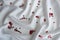 Red heart-shaped confetti lie on white satin fabric