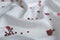 Red heart-shaped confetti lie on white satin fabric