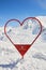 Red heart shaped frame on Val d\\\'Isere slopes in Winter, used for skiers to take photos with.