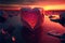 Red heart shaped ice block on frozen icy background at sunset valentine\\\'s love concept