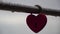 Red heart shaped padlock on metal railing of bridge. Love locks in the park - as symbols of eternal love, friendship and