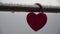 Red heart shaped padlock on metal railing of bridge. Love locks in the park - as symbols of eternal love, friendship and