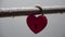 Red heart shaped padlock on metal railing of bridge. Love locks in the park - as symbols of eternal love, friendship and