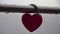 Red heart shaped padlock on metal railing of bridge. Love locks in the park - as symbols of eternal love, friendship and