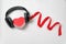 Red heart shaped with stereo headphones and a red ribbon on white background. Listen to your heart. Music of Heart