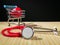 Red heart in shopping cart and classic red stethoscope on a simple organic bamboo table. Health care and medicine concept