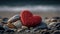 a red heart sitting on top of a pile of rocks.