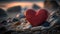 a red heart sitting on top of a pile of rocks.