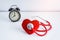 Red heart and stethoscope, alarm clock on table