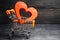 Red heart in the supermarket trolley. concept of buying love. Valentine`s Day. yellow background. Love of shopping. Favorite stor