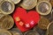 Red heart surrounded by various coins