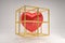 Red heart symbol in a golden cage  on a gray background, modern love concept.