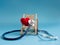 Red heart using deep blue stethoscope on the blue background. Concept of love and caring patient by the heart or get sick on trave