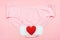 Red heart on white sanitary napkin and pink underpants on pink background.Woman hygiene, Concept of critical days, menstruation,