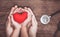 Red heart on woman and child hands and with doctor`s stethoscope