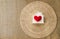 Red heart with the wood house on design round rattan tray with space on hessian fabric background