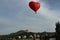 A red-hearted aerostat in the sky above the city. Romance.