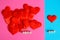 Red hearts on a blue and pink surface. Love and gender differences