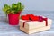 Red hearts on a box with gifts near a decorative bucket with flowers