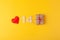 Red hearts, golden numbers 14, gift box on yellow background, greeting card february valentine's day