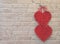 Red hearts hang on brick wall. Textured symbol of love. Lovers symbol