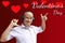 Red hearts hanging on the background, an elderly man in headphones shows fun on the words happy Valentines day poster background,