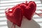 Red hearts of plush and play of shadows on a white background