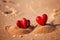 Red hearts together on the beach, showing holiday summer romance