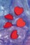 Red hearts in a violet slimy liquid.