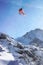 Red helicopter flying above Swiss Alpine mountain Mannlichen in