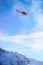 Red helicopter flying over Swiss Alpine mountain Mannlichen in w