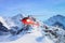 Red helicopter flying in Swiss Alps mountain Mannlichen in winter