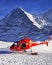 Red helicopter landed near alpine peak near Jungfrau mountain