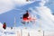 Red helicopter landing at Swiss Alpine mountain Mannlichen in wi