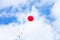 Red helium balloon high in the blue sky