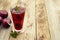 Red herbal and fruit tea in glass cup and tea with plums. Rustic textured wooden table. Copy space.