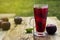 Red herbal and fruit tea in glass cup and tea with plums. Rustic textured wooden table. Copy space.