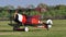 Red historical triplane combat aircraft drive in airfield