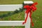 Red holiday ribbon bow green pine festoon white fence