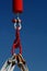 Red hook from capstan used on lifeboat crane, blue sky background