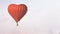 Red hot air balloon heart shape fly in winter village