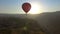 Red hot air balloon preparing for soft landing at mountain Armenian village