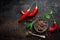 Red hot chili pepeprs and peppercorns on black metal background, top view, copy space for text