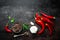 Red hot chili pepeprs and peppercorns on black metal background, top view, copy space for text