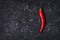 Red hot chili pepeprs and peppercorns on black stone background, top view