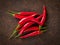 Red hot chili pepper on dark metallic rusty background, top view