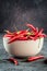 Red hot chilli pepper paprika in ceramic bowl on stone table Ingredient for Mexican cooking, Trendy toned image in rustic style